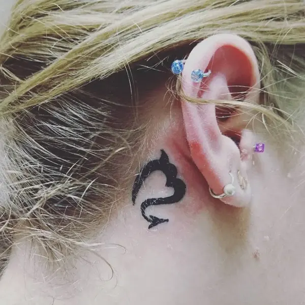 Tatuagem do signo de Escorpião atrás da orelha