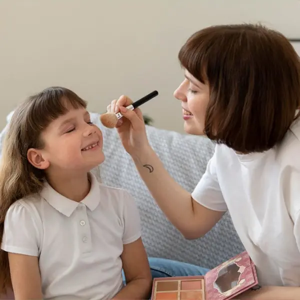 menina fazendo maquiagem com a mãe